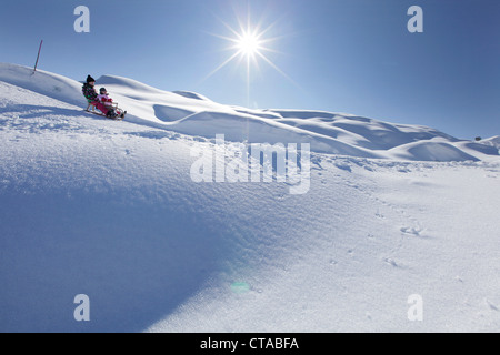 Zwei Mädchen, 12 und 2 Jahre auf einem Schlitten, Kloesterle, Arlberg, Tirol, Österreich Stockfoto