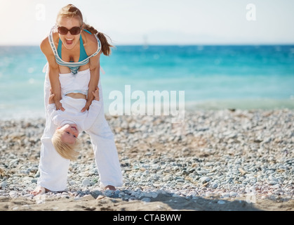 Mutter mit Baby am Strand spielen Stockfoto