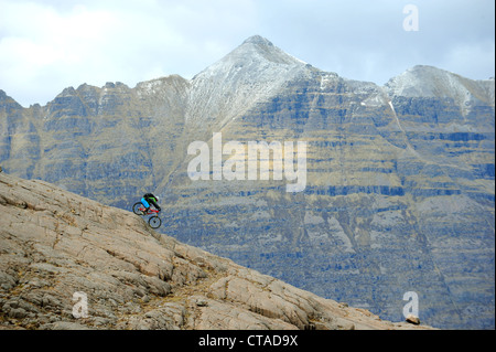 Ein Berg Biker fährt mit einem Felsenrücken im Bereich Wester Ross von der North West Highlands, Schottland. Stockfoto