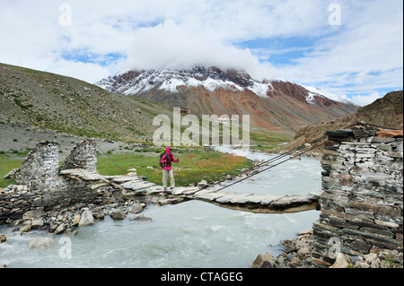 Frau Kreuzung Fluss auf Aufhebung-Brücke, in der Nähe von sie, zwischen Testa und Lakang Sumdo, Zanskar Bereich durchqueren, Zanskar Range, Zans Stockfoto