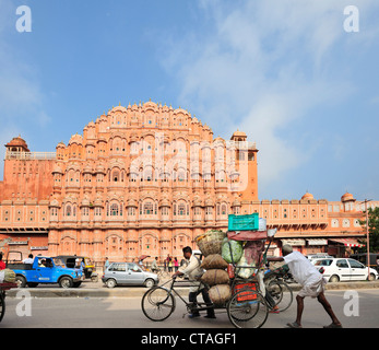 Zwei Männer schieben geladen Rikscha vor Palast der Winde, Palast der Winde, Hawa Mahal, Jaipur, Rajasthan, Indien Stockfoto