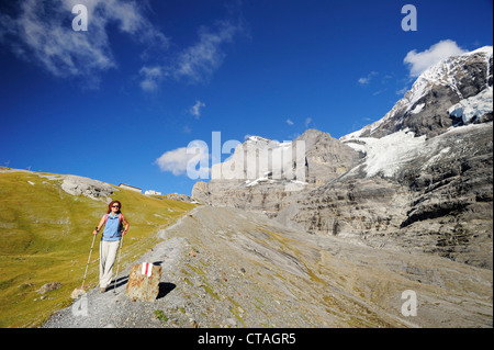 Frau beim Abstieg, Eiger und Mönch im Hintergrund, UNESCO World Heritage Site Jungfrau-Aletsch geschützten Gebiet, Berner Oberland, Stockfoto