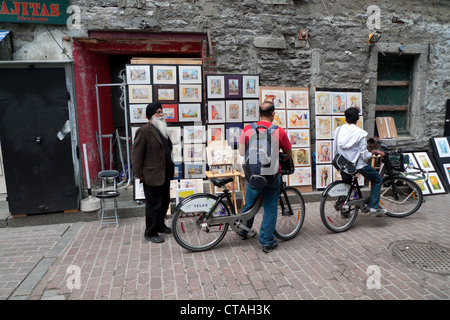 Touristen, die die Gemälde des älteren Sikh Künstlers in einer Gasse hinter Rue Saint Paul Est Montreal Quebec Kanada KATHY DEWITT anzeigen Stockfoto