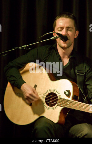 Barry spielt einer Stahlsaite akustische Gitarre mit "Púca" eine traditionelle irische Musik-Band spielt im Arlington Hotel, Dublin. Stockfoto