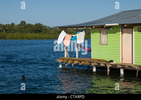 Bunte grünes Haus mit Wäsche weht auf Isla Colon, Bocas del Toro, Panama. Stockfoto