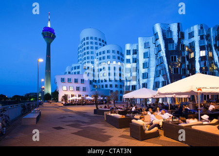 Restaurant-Terrasse, Gehry-Bauten und Rheinturm Turm am Abend, Neuer Zollhof (Architekt: F.O Gehry), Medienhafen, Du Stockfoto