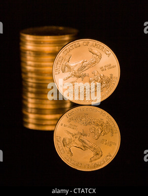 Reflexion der einzelnen Goldmünze und Stack auf schwarze polierte Oberfläche Stockfoto