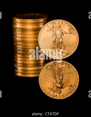 Reflexion der einzelnen Goldmünze und Stack auf schwarze polierte Oberfläche Stockfoto