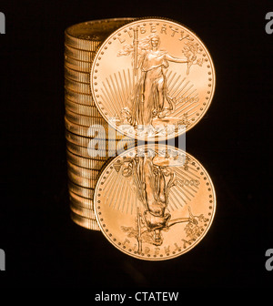 Reflexion der einzelnen Goldmünze und Stack auf schwarze polierte Oberfläche Stockfoto
