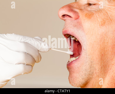 Behandschuhte Hand unter einem körperlich Fluid-Probe für DNA-Test von ältere männliche person Stockfoto