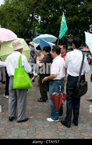 Eine offizielle Reiseführer hält seine Fahne zu seiner Reisegruppe zu sehen, die Sehenswürdigkeiten in Bangkok, Thailand Stockfoto