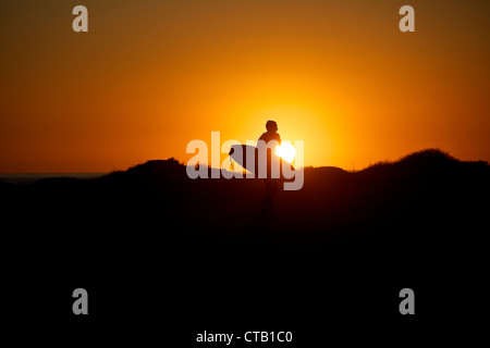 Surfer am Strand entlang spazieren, während des Sonnenuntergangs, Los Angeles, Kalifornien, USA Stockfoto