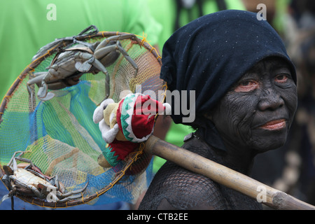 Frau mit Gesichts Malerei hält Angebote bei Ati-Atihan Festival, Ibajay, Aklan, Insel Panay, Visayas, Philippinen Stockfoto