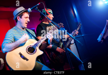 Musiker spielt eine Gitarre auf einem dunklen Hintergrund Stockfoto