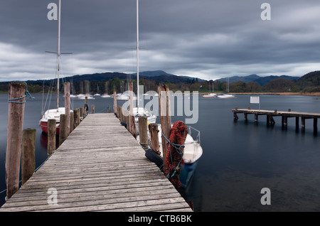 Abend auf Windermere, Lake District bedeckt. Hölzerne Piers, Yachten und Hügeln in der Ferne. Stockfoto