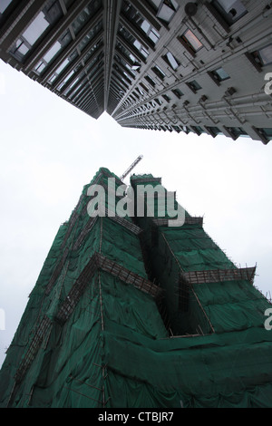 Es ist ein Foto von einem Turm in Hong Kong Untersicht. Es ist in Sicht und ein sehr hohes Gebäude. Wir sehen auch Gerüste Stockfoto