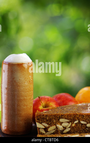 Becher Bier, Brot und Obst Stockfoto