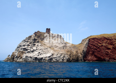 Vulkanische Formationen und alten Turm auf der Oberseite, Capraia Insel, Toskanischer Archipel, Italien. Stockfoto