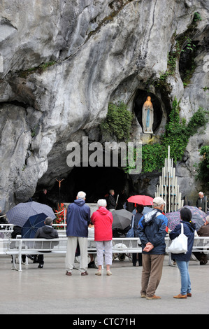 Pilger beten vor der Grotte an der Wallfahrtskirche unserer lieben Frau von Lourdes, Pyrenäen, Frankreich Stockfoto