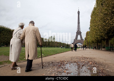 Ein älteres Ehepaar geht in einem Park nahe des Eiffelturms in Paris, Frankreich. Stockfoto