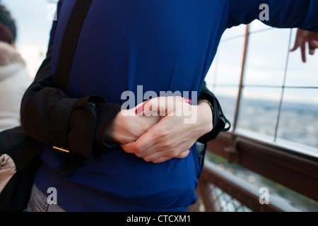 Ein paar umarmt auf der zweiten Etage des Eiffelturms in Paris, Frankreich. Stockfoto