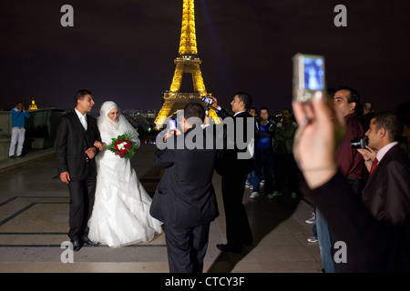 Ein frisch verheiratetes Paar arabischen stellt für Fotos im Trocadero Eiffelturm in Paris, Frankreich. Stockfoto