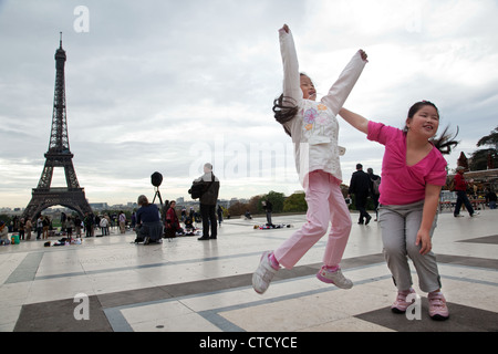 Junge chinesische Touristen posieren für Fotos im Trocadero nahe des Eiffelturms in Paris, Frankreich. Stockfoto