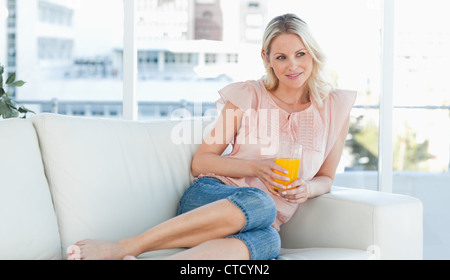 Blonde Frau auf einem Sofa liegend Stockfoto