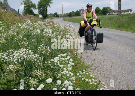 Lady Fahrrad Touren entlang einer französischen Straße in der Bretagne Stockfoto