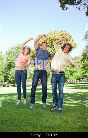 Drei Studenten, die während der Erziehung eines Arms springen Stockfoto