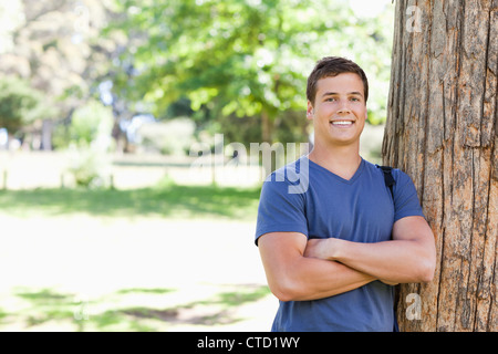 Porträt eines muskulösen Studenten an einen Baum gelehnt Stockfoto