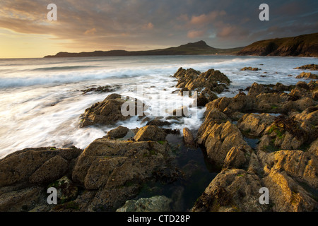 Sonnenuntergang über den Felsen am Porthselau Strand mit Blick auf St. Davids Kopf, Pembrokeshire, Wales Stockfoto