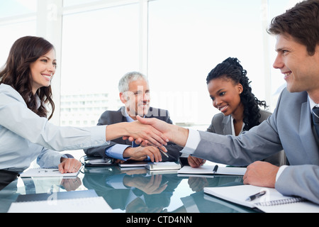 Vorstand junge Frau und ein Kollege Händeschütteln während eines Meetings Stockfoto