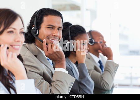 Junge Call-Center-Mitarbeiter arbeiten unter seinem team Stockfoto