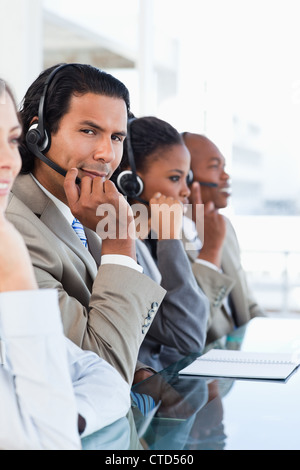 Junge Call-Center-Mitarbeiter umgeben von seiner Business-team Stockfoto