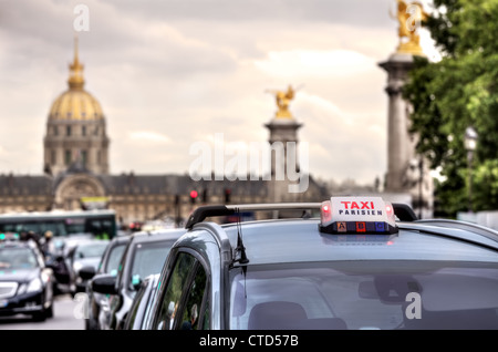 Paris Taxi beleuchtete Zeichen auf dem Autodach und Les Invalides auf dem Hintergrund in Paris, Frankreich. Stockfoto