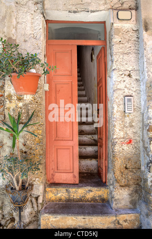 Vertikal orientierte Bild der Holztür und alte schmale Treppe im kleinen Haus am Stadt von Ventimiglia in Ligurien, Italien. Stockfoto