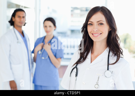 Junge Krankenschwester stand vor zwei Kollegen Stockfoto
