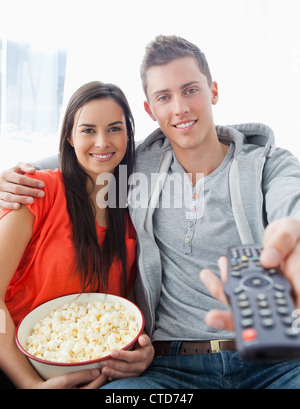 Fokus auf das Paar sitzt auf der Couch mit Popcorn erschossen hautnah Stockfoto