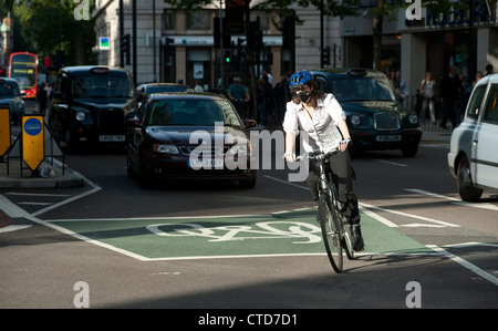 Radfahrer, Radfahren in London Verkehr tragen Schutzhelm und Gesichtsmaske. Stockfoto