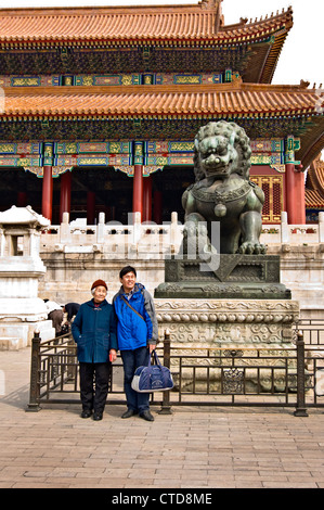 Zwei chinesische Touristen posieren vor dem Löwen das Tor der höchsten Harmonie in der verbotenen Stadt - Peking, China Stockfoto