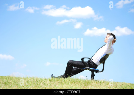 Geschäftsmann am Stuhl in der Natur entspannen Stockfoto