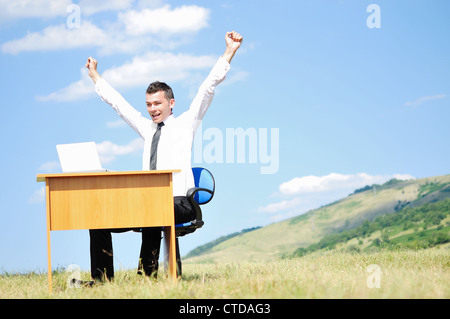 Geschäftsmann am Schalter in der Natur Stockfoto