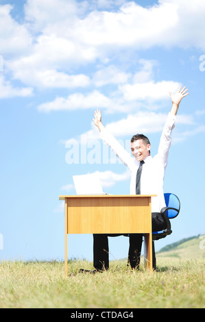 Geschäftsmann am Schalter in der Natur Stockfoto