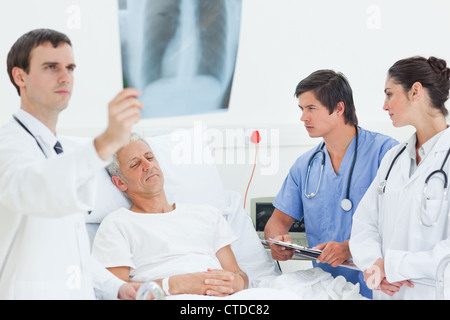 Arzt eine Röntgenaufnahme Scan stehen neben einem Patienten mit seinen Augen betrachten geschlossen Stockfoto