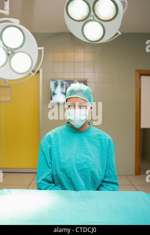 Krankenschwester, die sitzt hinter dem OP-Tisch Stockfoto