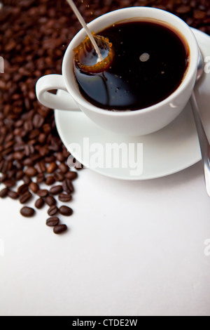 Milch in eine Tasse Kaffee gegossen Stockfoto