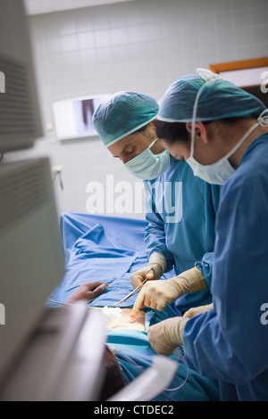 Seitliche Sicht auf ein Team von Chirurgen, die eine Operation zu tun Stockfoto