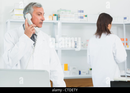 Das Telefonieren in einer Apotheke mit einem anderen Apotheker Apotheker Stockfoto