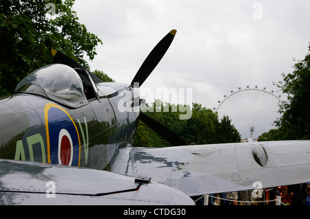 Ein Spitfire im St James' Park mit dem London Eye Stockfoto